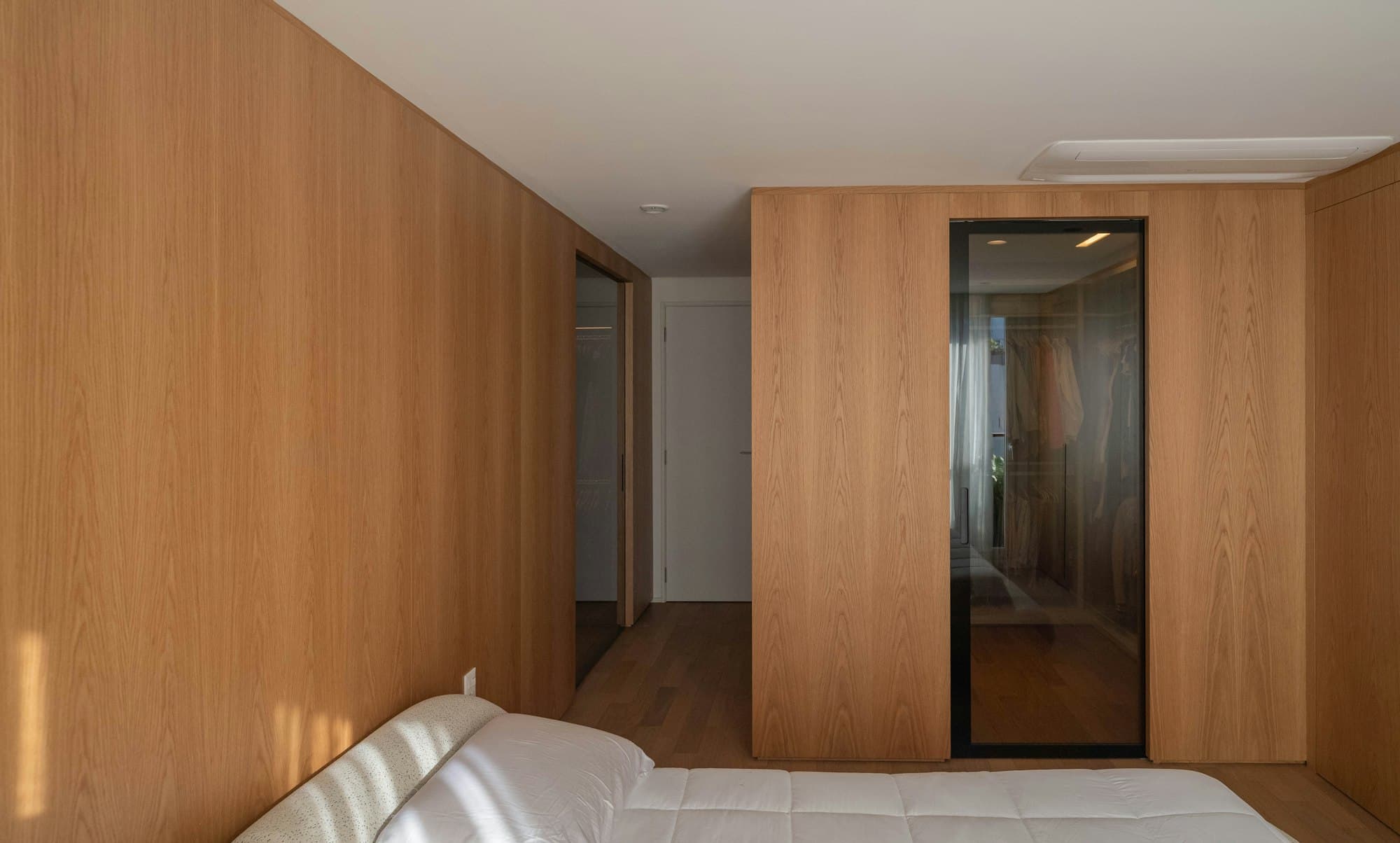 Schlafzimmer mit Holzwand und integrierten Türen