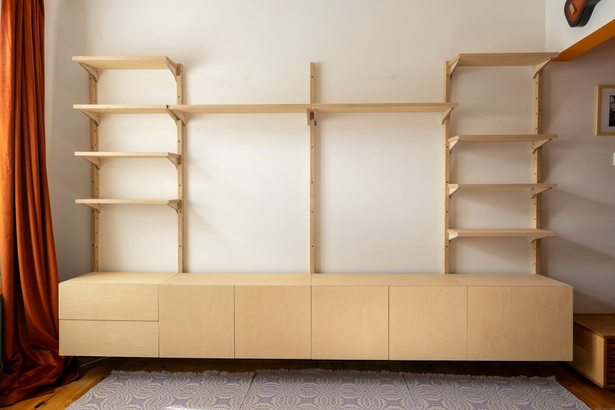 Helle Holzwohnwand mit offenen Regalen und Sideboard