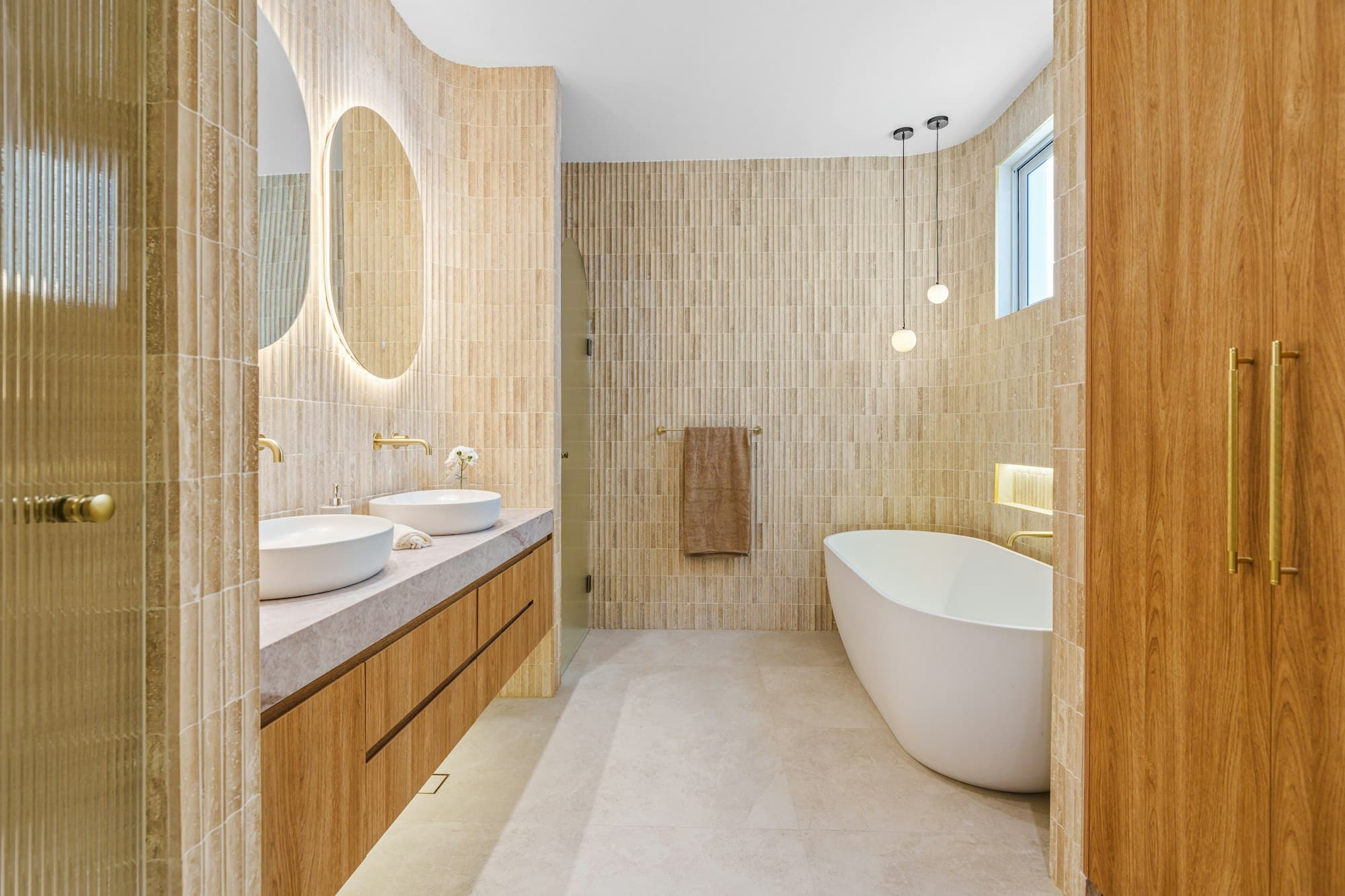 Modernes Bad mit Holzelementen, Doppelwaschtisch und freistehender Wanne